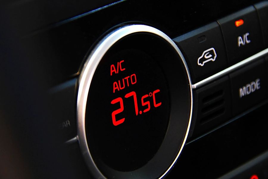 A car's climate control display set to A/C auto